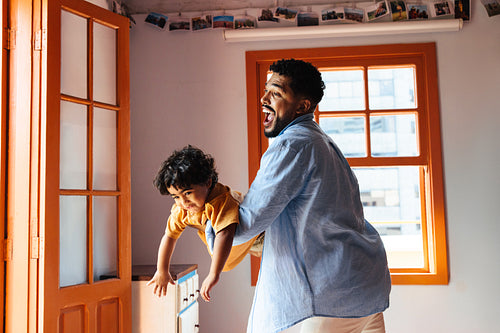 Father playing with his son in a bright and cheerful home setting
