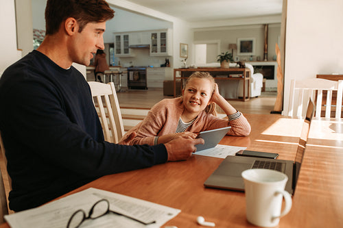 Father and daughter with digital tablet at home