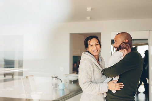 Parents with newborn baby boy in kitchen