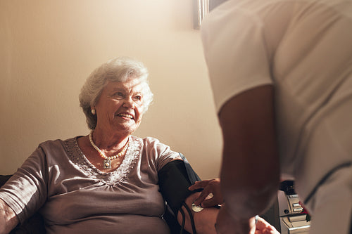 Elderly woman getting routine check from a female doctor