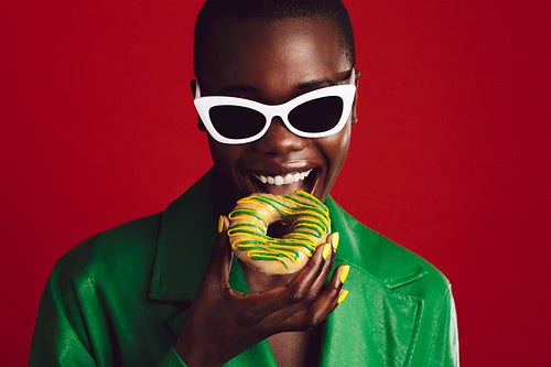 Fashionable woman eating donut