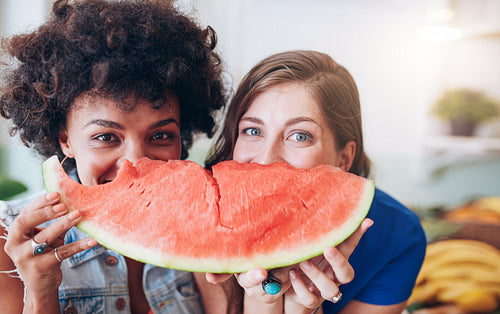 Two young women holding slice of watermelon