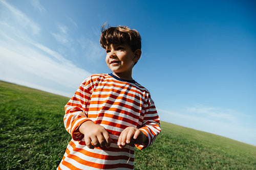 Boy in striped shirt playing outdoors