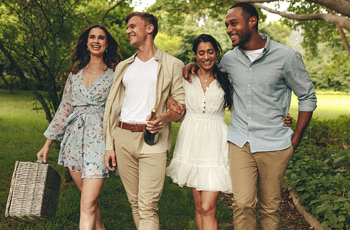 Friends group walking to the picnic spot in the garden