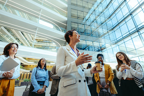Female executive welcoming new hires in modern office lobby