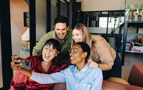 Young professionals engaging in a joyful discussion in a modern office space