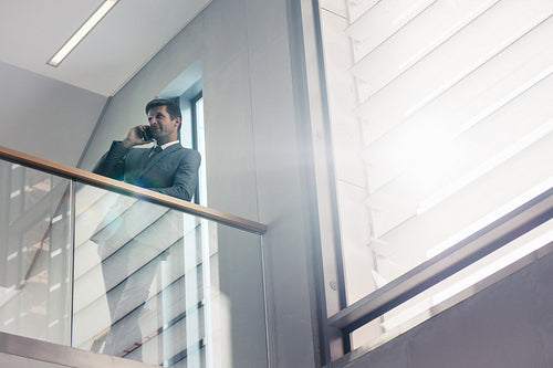 Businessman talking on mobile phone in office
