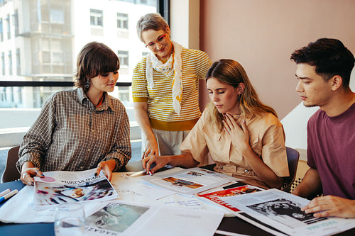 High school class project in a city setting with students working together on a creative assignment, guided by a teacher