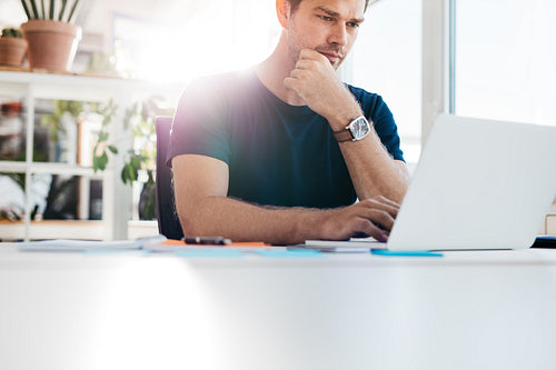 Young man at office working on laptop