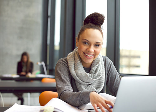 Happy young woman studies in the library