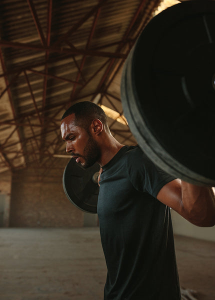 Fitness man doing squats with heavy weights