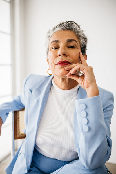 Empowerment and elegance: Mature woman sits in her office, dressed in a suit