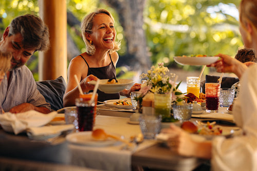 Joyful laughter during brunch at a luxurious island villa with friends
