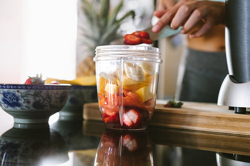 Woman preparing healthy juice from fresh fruits