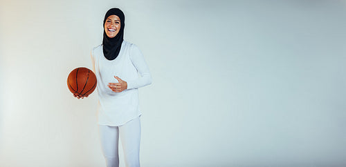 Smiling female athlete playing basketball