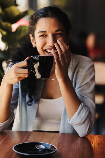 African woman having coffee at coffee shop