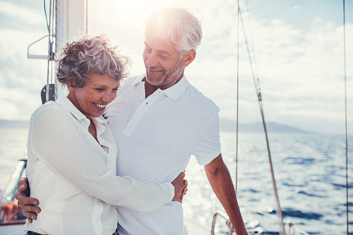 Romantic senior couple standing on sailboat