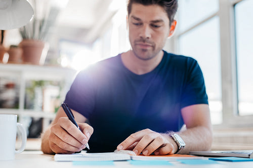 Young businessman updating his personal organizer