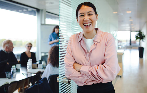 Cheerful female professional outside boardroom
