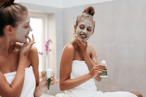 Young woman applying facepack in bathroom