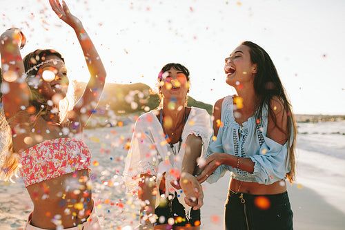 Happy young female friends partying on the beach