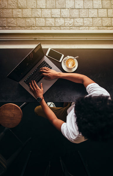 Young man sitting at coffee shop and working on laptop