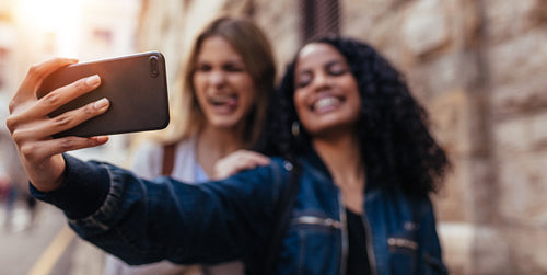Two women clicking a selfie outdoors