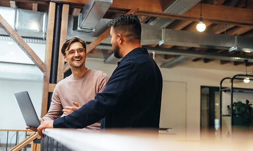 Two business men talking to each other about their tech work