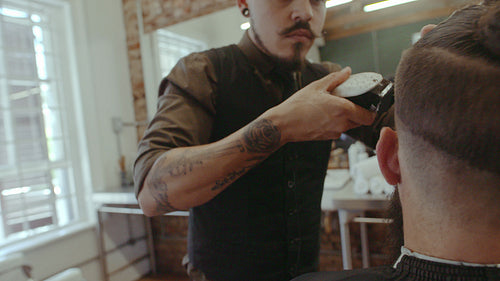 Professional barber giving a trendy haircut to client
