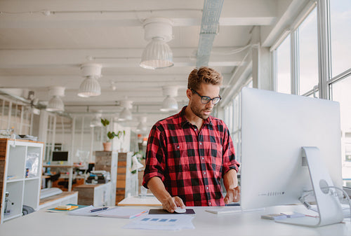 Young man working on computer in modern office