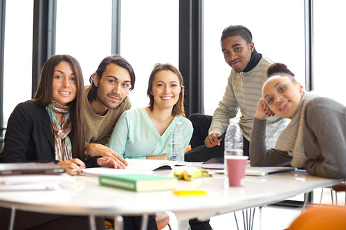 Happy young students at table studying together