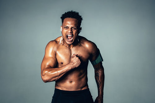 Shirtless male model with muscular physique shouting