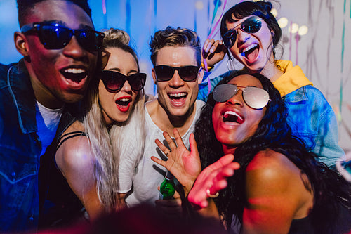 Young men and women posing for a photo at a house party 