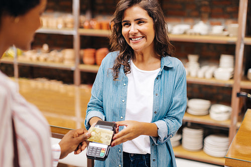 Happy store manager receiving a contactless credit card payment