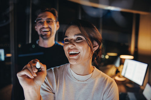 Brainstorming into the night: Business team collaborating behind and office glass wall