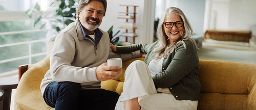 Senior couple relax together on a sofa at home