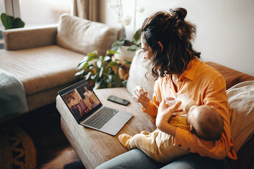 Mother on video call with baby feeding