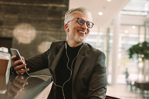 Smiling businessman sitting relaxed at cafe