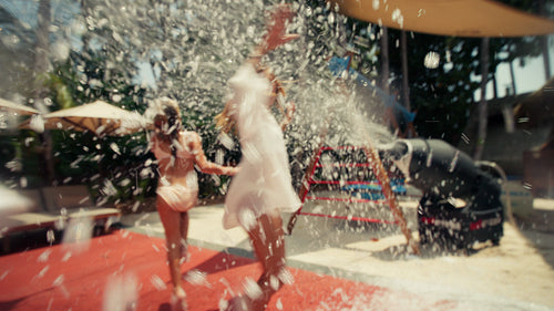 Joyful mother and daughter playing in a fun foam party on a sunny day