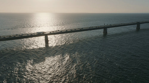 The Great Belt Bridge at sunset, with a view of moving traffic and tranquil sea waters