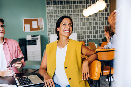 Smiling woman in a modern workspace during a group discussion