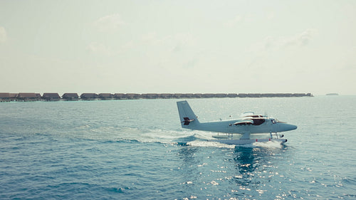 Seaplane arrival at a luxury tropical resort with overwater bungalows in the Maldives