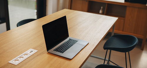 Empty meeting room with an open laptop