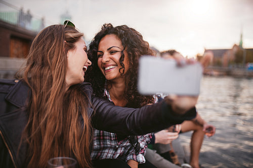 Female friends taking selfie by the lake