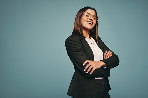 Smiling young woman standing with her arms crossed