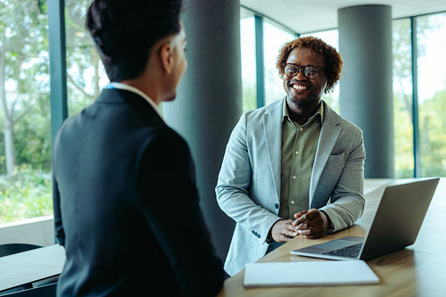 Friendly coworkers engaging in a bright modern office setting