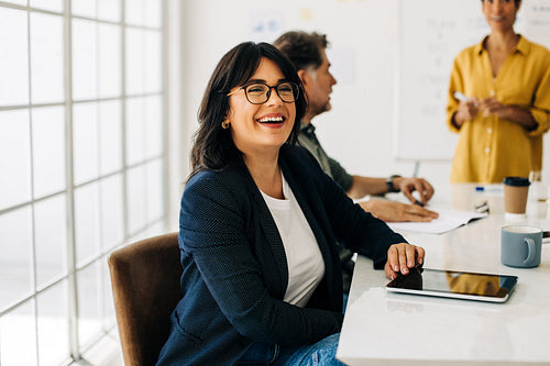 Successful business woman sitting in a boardroom with her colleagues