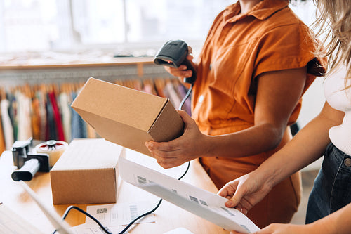 Clothing store owner scanning a parcel box in a shop