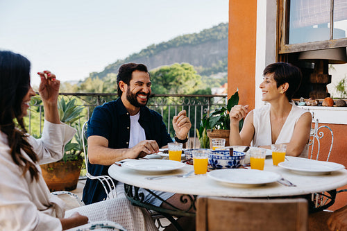Group enjoying a meal outdoors with laughter and conversation