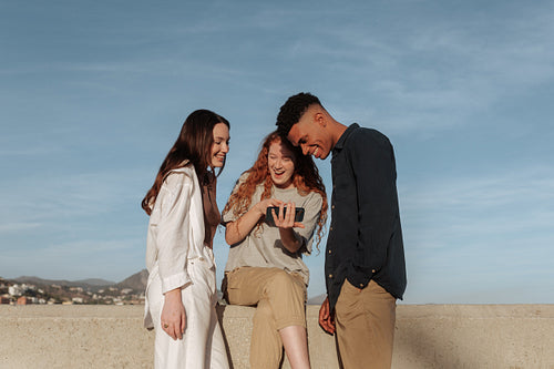 Happy young people video calling their friends outdoors